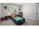 Fun bedroom with a race car bed, a window with blinds, and a shelf for toys at 147 Gentry Dr, Pittsboro, NC 27312