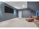 Spacious bonus room featuring blue walls, plush carpeting, and comfortable sofa set for relaxation and entertainment at 147 Gentry Dr, Pittsboro, NC 27312