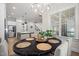 Bright dining room featuring an oval table and decorative chandelier, seamlessly flowing into the open kitchen area at 147 Gentry Dr, Pittsboro, NC 27312