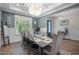 A dining room is shown featuring a decorative chandelier, large window, and a rustic wood dining table at 147 Gentry Dr, Pittsboro, NC 27312