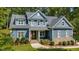 Charming two-story home with blue siding, stone accents, landscaped yard and American flag at 147 Gentry Dr, Pittsboro, NC 27312