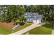 A two-story home featuring stone accents, a three-car garage, and a landscaped front yard at 147 Gentry Dr, Pittsboro, NC 27312