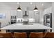 The kitchen has an island with bar stool seating, white cabinets, stainless steel appliances, and hardwood floors at 147 Gentry Dr, Pittsboro, NC 27312