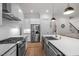 Kitchen is showcased with stainless steel appliances, white cabinets, a kitchen island, and a view of the staircase at 147 Gentry Dr, Pittsboro, NC 27312
