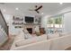Cozy living room with a large sectional sofa, fireplace, built-in shelving, and sliding doors to the outdoor living space at 147 Gentry Dr, Pittsboro, NC 27312