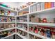 This pantry has shelves filled with a variety of foods and household items in bins, baskets, and original packaging at 147 Gentry Dr, Pittsboro, NC 27312