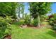 Private backyard features a stone fire pit, mature trees, and lush landscaping at 150 Teal Dr, Youngsville, NC 27596