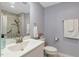 Modern bathroom with white vanity, toilet, and marble-tiled shower with glass door, and soft grey walls at 150 Teal Dr, Youngsville, NC 27596