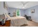 Bright bedroom with light blue walls, a ceiling fan, and a bed with floral bedding, and a desk at 150 Teal Dr, Youngsville, NC 27596