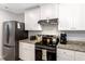 Kitchen with granite countertops, stainless steel appliances, and white cabinetry at 150 Teal Dr, Youngsville, NC 27596