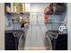 Efficient laundry room with black washer and dryer units and ample shelving for storage, and light wood flooring at 150 Teal Dr, Youngsville, NC 27596