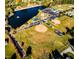 Aerial view showcasing community amenities including a lake, playground, tennis courts, and sports fields at 158 Vaughan Farms Drive Dr, Angier, NC 27501