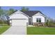 Charming single-Gathering home boasts white siding, stone accents, a green front door, and a well-manicured lawn at 158 Vaughan Farms Drive Dr, Angier, NC 27501
