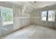Unfinished bedroom with a vaulted ceiling and walls ready for paint with two windows at 1701 Burnette Garden Path, Raleigh, NC 27612