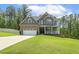 Charming two-story home featuring a stone facade, a two-car garage, and a welcoming front porch at 187 Farrah-Shea Way, Angier, NC 27501