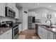 Bright kitchen with white cabinets, stainless steel appliances, and hardwood floors at 206 Heart Pine Dr, Wendell, NC 27591