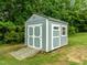 A backyard shed with a ramp and white trim is set among lush trees at 206 Heart Pine Dr, Wendell, NC 27591