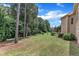 Mature trees border a green lawn with pine straw in the backyard of this home at 212 Fieldtrial Cir, Garner, NC 27529