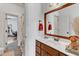 Bathroom featuring a wooden vanity, decorative mirror, and view into an adjacent room at 212 Fieldtrial Cir, Garner, NC 27529