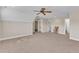 A large carpeted bonus room featuring a ceiling fan, neutral paint, and access to additional spaces at 212 Fieldtrial Cir, Garner, NC 27529