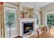 Cozy dining area with a charming brick fireplace and mantle, flanked by windows with natural light and hardwood floors at 212 Fieldtrial Cir, Garner, NC 27529