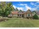 Charming home with a manicured lawn, stone accents, and inviting front porch at 212 Fieldtrial Cir, Garner, NC 27529