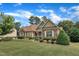 Attractive home featuring stone and siding accents, a green lawn, and lush landscaping at 212 Fieldtrial Cir, Garner, NC 27529