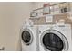 Bright laundry room with washer, dryer, and shelving for storage with decorative items at 212 Fieldtrial Cir, Garner, NC 27529