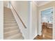 Carpeted staircase leading upstairs, with a view into a bedroom showcasing hardwood floors at 212 Fieldtrial Cir, Garner, NC 27529
