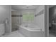 Bright bathroom featuring a jacuzzi tub with glass block window and a separate glass-enclosed shower at 215 Collinson Dr, Chapel Hill, NC 27514