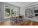 Dining area with a modern table, large windows, and view into the living room with a fireplace at 215 Collinson Dr, Chapel Hill, NC 27514