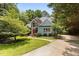 Well-maintained home with manicured landscaping, blue siding, and brick accents surrounded by mature trees at 215 Collinson Dr, Chapel Hill, NC 27514