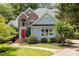 Charming two-story home with a red front door, brick accents, manicured landscaping, and a walkway leading to the entrance at 215 Collinson Dr, Chapel Hill, NC 27514