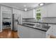 Bright kitchen featuring white cabinets, stainless steel appliances, and granite countertops, with a view into the dining area at 215 Collinson Dr, Chapel Hill, NC 27514