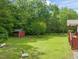 Spacious backyard with a storage shed, level lawn, and mature shade trees at 215 Virginia Pine Dr, Clayton, NC 27520