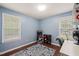 Well-lit room with hardwood floors, bright blue walls, and two large windows at 215 Virginia Pine Dr, Clayton, NC 27520
