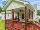 Charming covered deck with red painted wood, ceiling fan, and a view of the yard at 215 Virginia Pine Dr, Clayton, NC 27520
