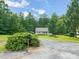 A cozy home nestled among trees, featuring a carport and charming landscaping at 215 Virginia Pine Dr, Clayton, NC 27520