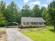 Inviting single-story home with a covered porch, carport, and lush greenery at 215 Virginia Pine Dr, Clayton, NC 27520