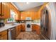 Well-lit kitchen featuring wooden cabinets, stainless steel appliances, and earth-toned tile flooring at 215 Virginia Pine Dr, Clayton, NC 27520