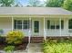 Inviting front porch with white railings, a storm door, and decorative shutters at 215 Virginia Pine Dr, Clayton, NC 27520