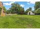 View of the lush green backyard with a wooden shed at 2423 Northern Bnd, Burlington, NC 27217