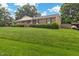 Expansive front lawn leading to a welcoming brick ranch home at 2423 Northern Bnd, Burlington, NC 27217