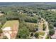 Aerial view of property amid lush greenery; a sports field and residential homes are also visible at 25 Spicetree Ct, Youngsville, NC 27596