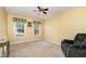 Bedroom features light yellow walls, a ceiling fan, two windows, and a lounge chair at 25 Spicetree Ct, Youngsville, NC 27596