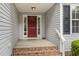 Inviting front entry featuring a red door, brick steps, and classic siding at 25 Spicetree Ct, Youngsville, NC 27596