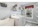 Laundry room features a washer, dryer, utility sink, and storage shelves at 25 Spicetree Ct, Youngsville, NC 27596
