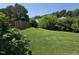 Expansive backyard with a wooden fence, mature trees, and verdant lawn at 2511 Dalmahoy Ln, Fuquay Varina, NC 27526