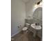 Half bathroom featuring a pedestal sink, toilet, and decorative mirror at 2511 Dalmahoy Ln, Fuquay Varina, NC 27526