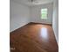 A bedroom with hardwood floors and a view of the trees from the window at 2511 Dalmahoy Ln, Fuquay Varina, NC 27526
